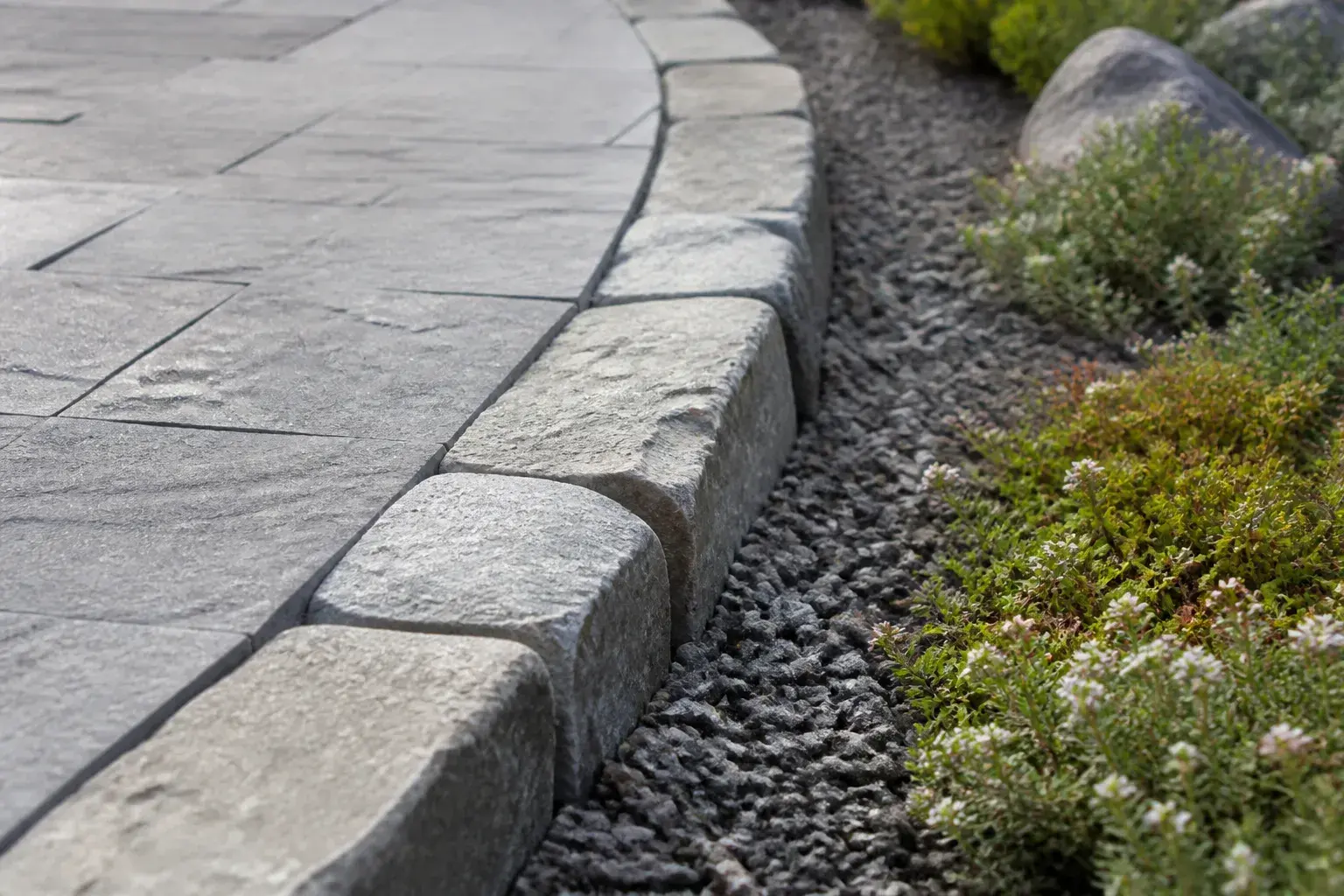 Stone walkway edge with gravel and groundcover